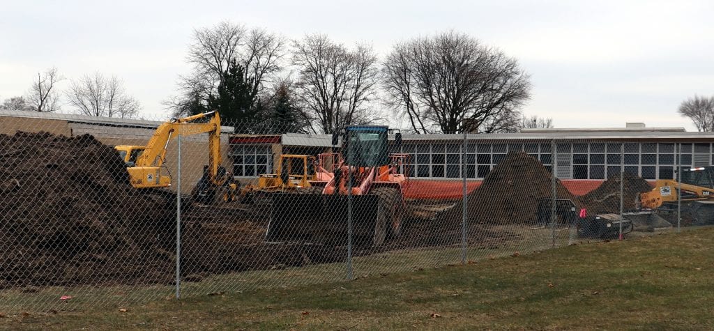 Earth moving equipment and mounds of dirt as construction continues at Dearborn High School.