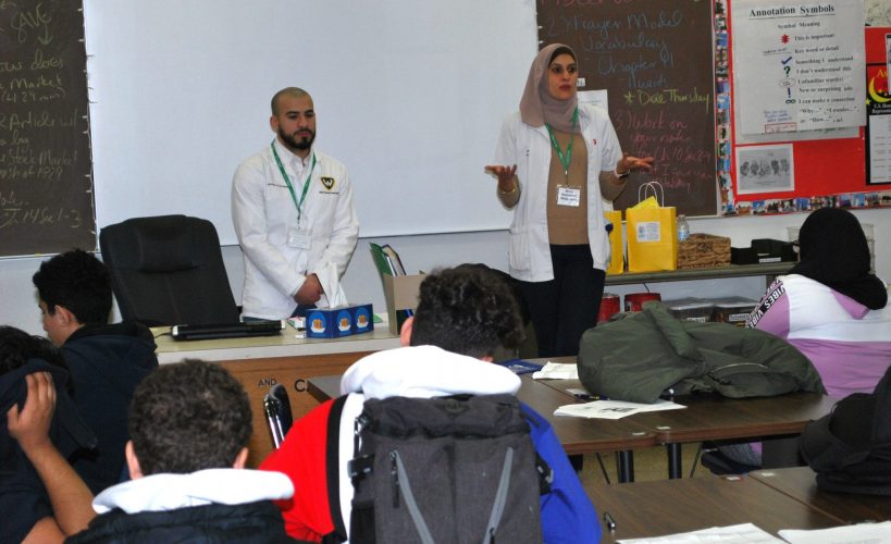 Two pharmacists talk to students during the Fordson High School Career Fair in December 2019.