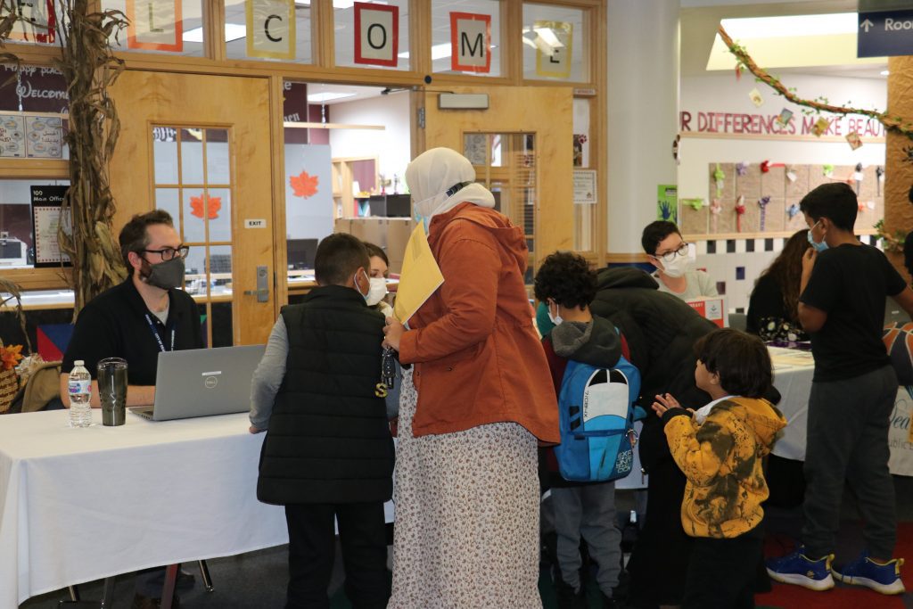 A group of parents and students sign up for Dearborn Public Library cards during a library card drive at Salina School in November 2021.