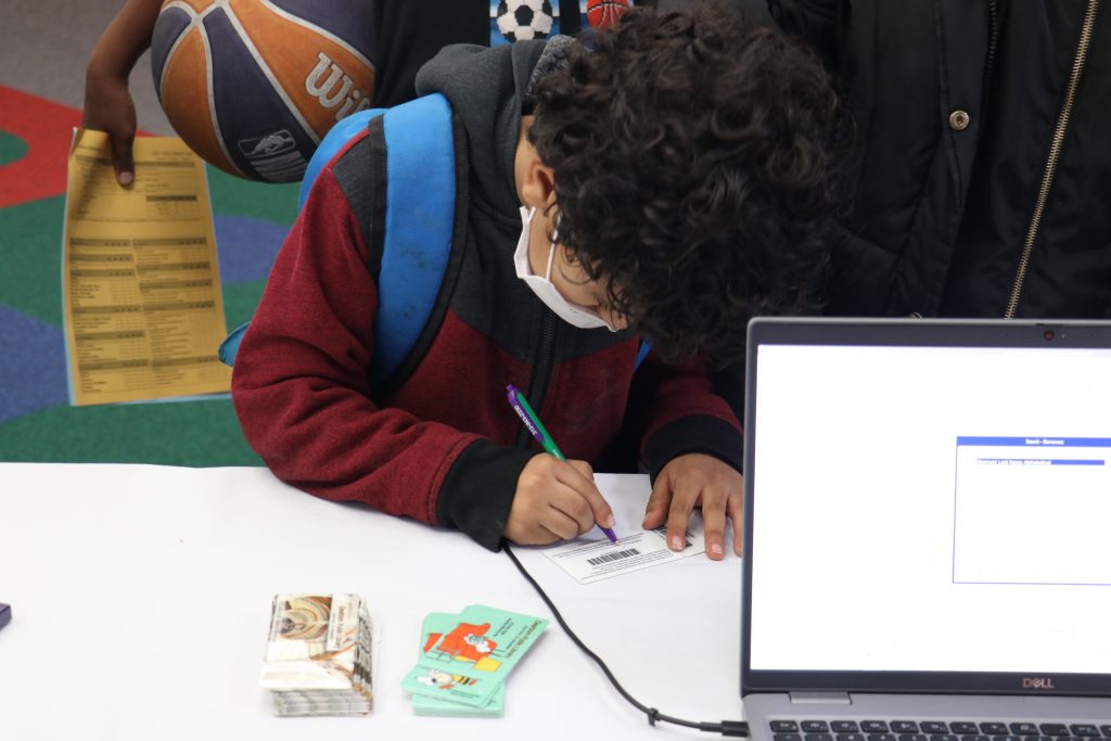 A student fills out paperwork to get a Dearborn Library Card during a library card drive at Salina School in November 2021.