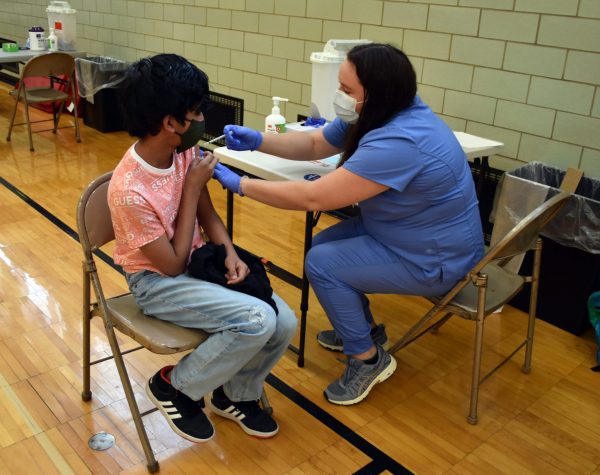 A student gets a shot from a nurse during a COVID vaccination clinic at Edsel Ford High in May 2021.