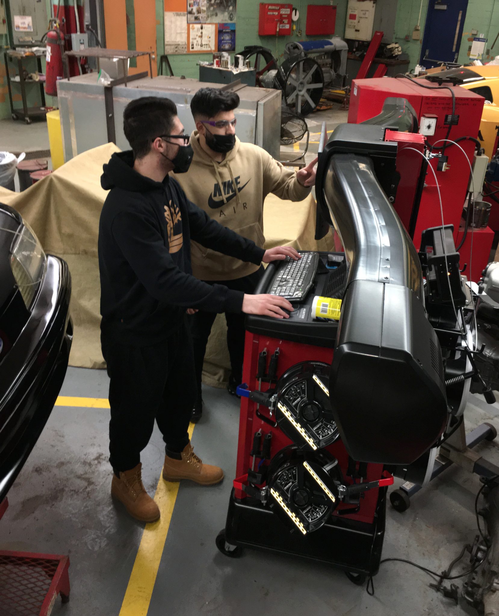 Two Fordson High students use a new alignment machine in their auto tech class on Jan. 5, 2022.