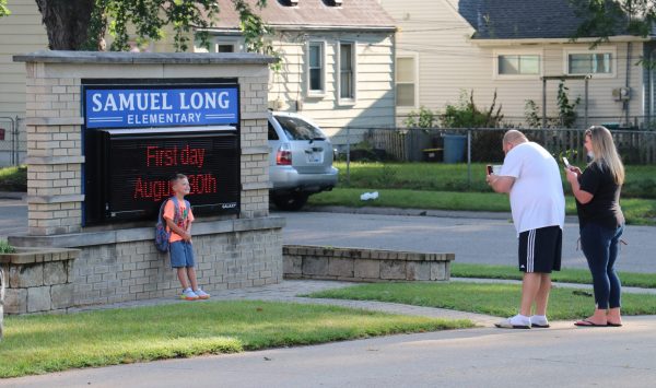 A child poses for a photo in front of the Long Elementary School sign in August 2021.