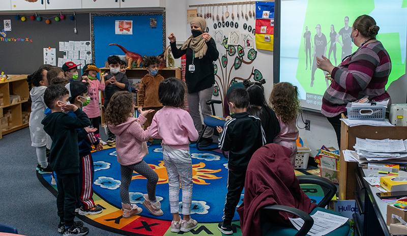 GSRP preschool students and two adults move along with a kid video at Cotter School in March 2022.