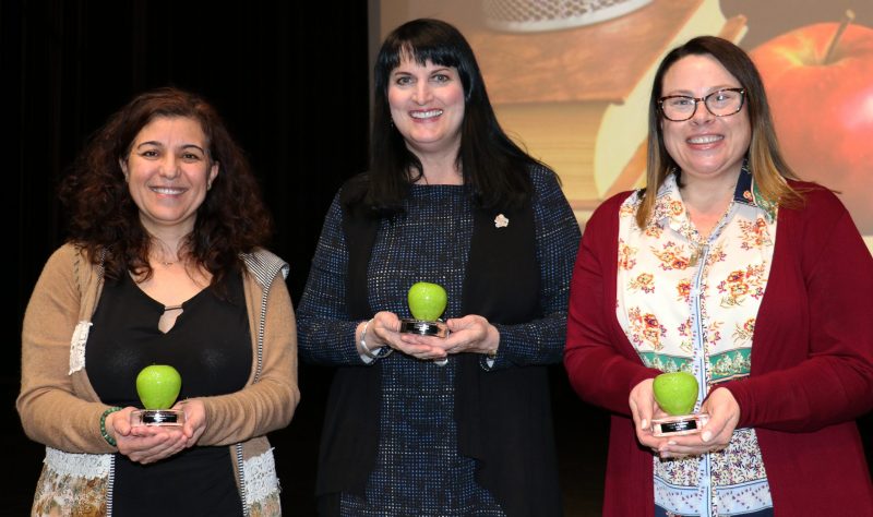 Three women hold glass Teacher of the Year Awards including Haifaa Mourad-Chamma, Cathy Tade and Sarah Verrier.