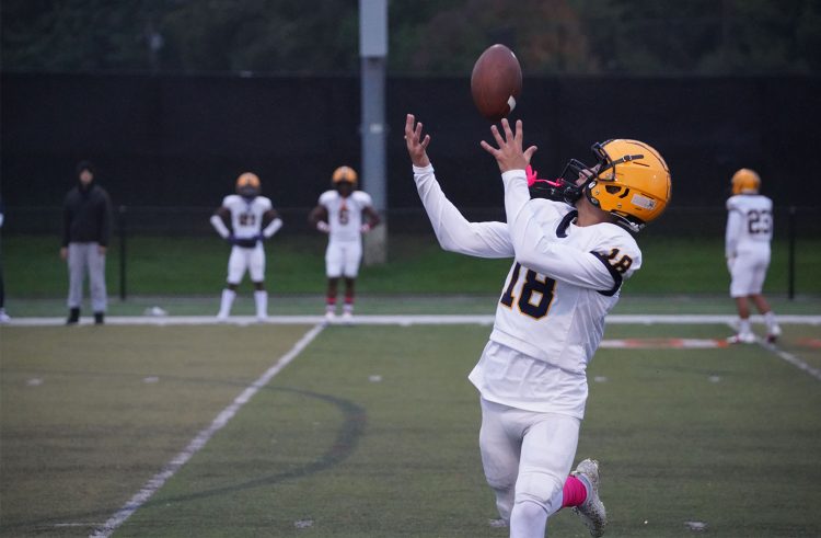 A Fordson football player looks over his shoulder as he catches a pass.