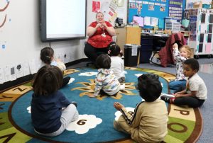 The teacher leads students in singing at Strong Beginnings preschool.