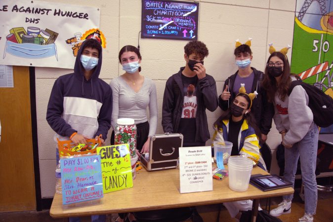 Dearborn High students stand at a table during school lunch raising money for Battle Against Hunger.