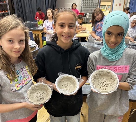 Three girls at Snow Elementary show off clay bowls they made for Empty Bowls on Nov. 13, 2023.