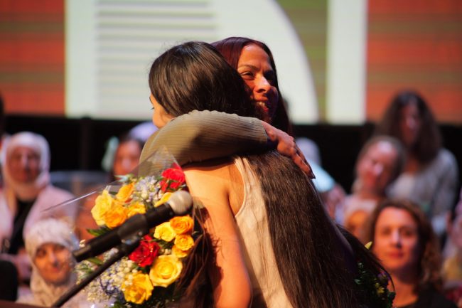 A student and teacher hug at the 2024 Superintendent's Honors Night
