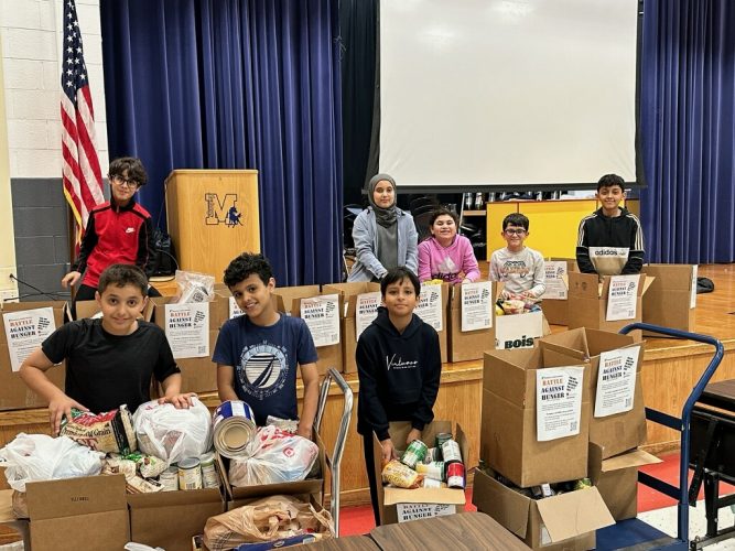 Students pack donated food into boxes at Miller Elementary in the fall of 2023