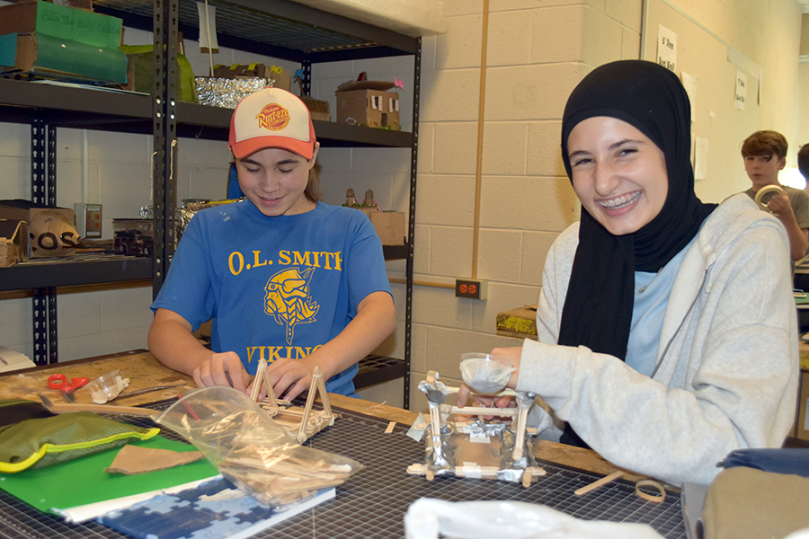 Two STEM students work on creating a catapult out of craft sticks