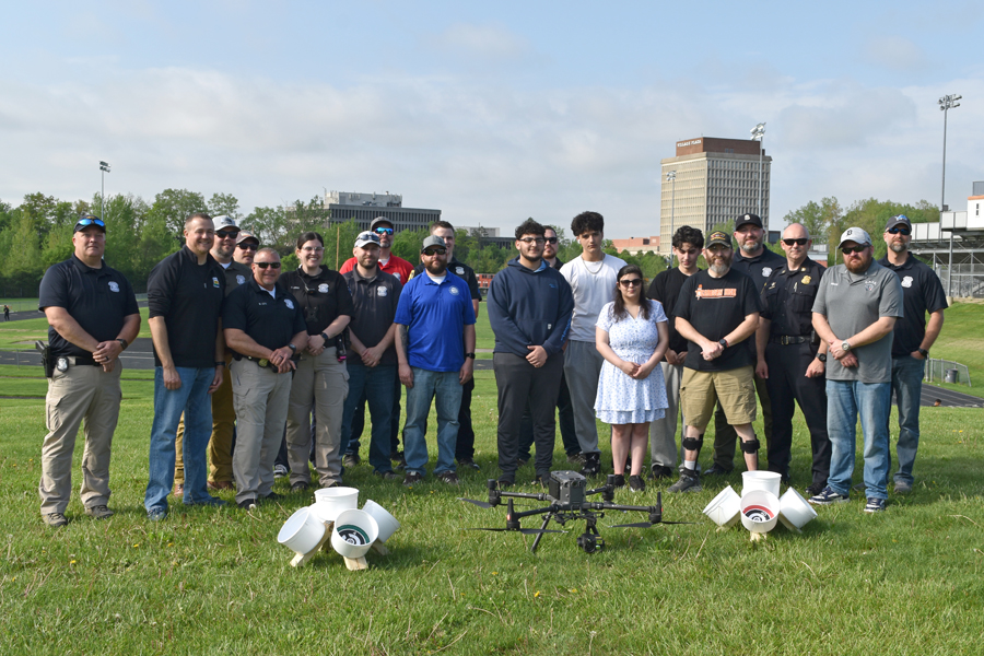 Dearborn Police officers and Dearborn High students gather in front of targets the students built for the offices to practice with the police drone.