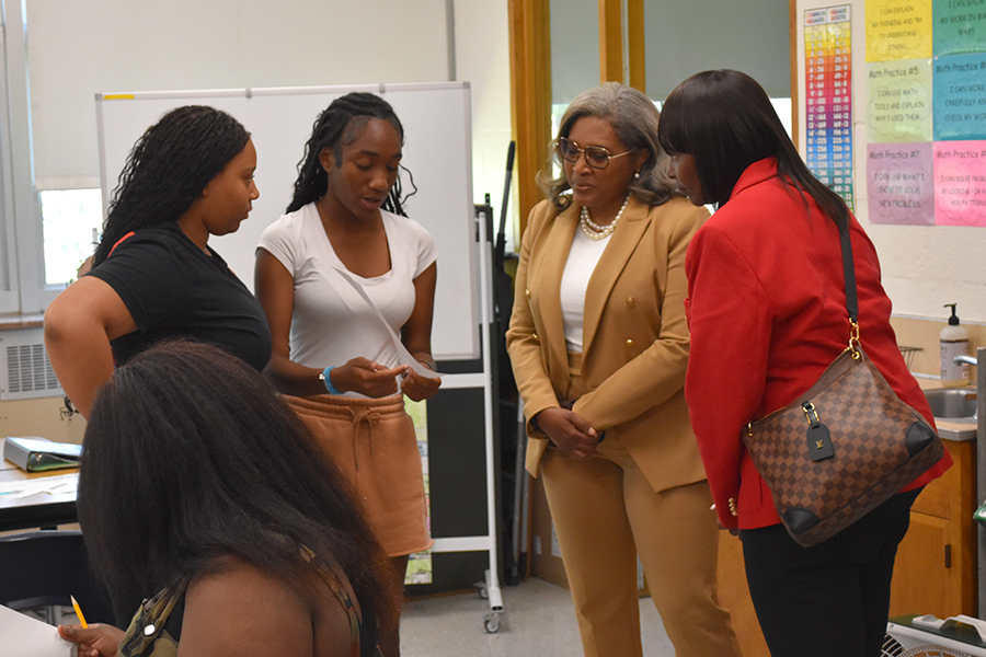 Two Smith Middle School students talk to Michigan State Board of Education President Dr. Pamela Pugh, second from the right, and Wayne RESA Superintendent Dr. Daveda Colbert.