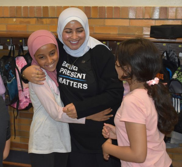 Zahra Makkawi smiles as she hugs a student at Oakman Elementary.