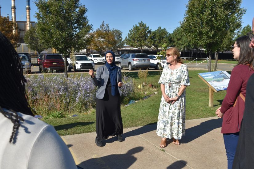 Salina principals by raingarden Salina Intermediate Principal Eman Ali and Elementary Principal Sue Stanley talk in front of a flowering rain garden on the school campus.