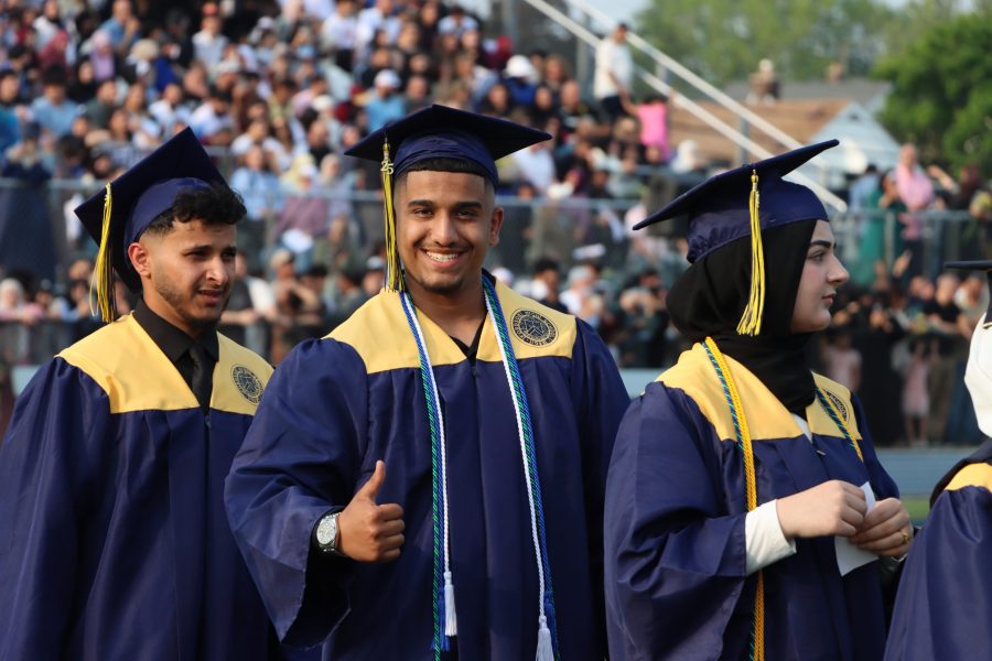 A student gives a thumbs up while in line at the Fordson High School graduation.