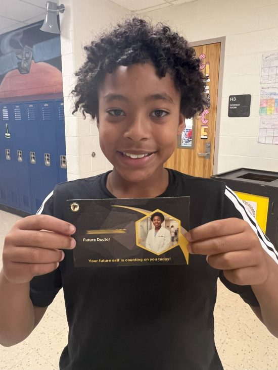 A student shows a card showing an older version of himself as a doctor.
