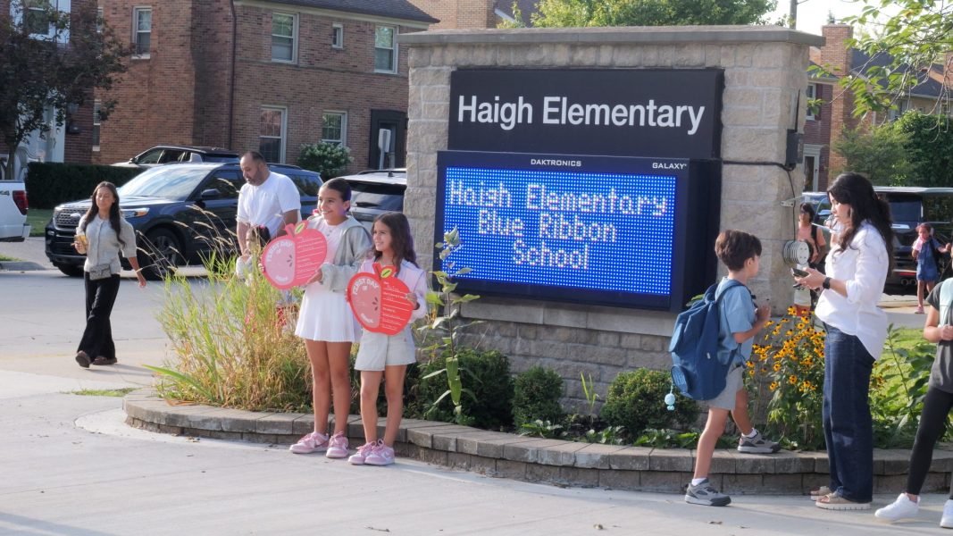 Two Haigh students pose for a photo in front of the school sign on the first day of school in 2025.