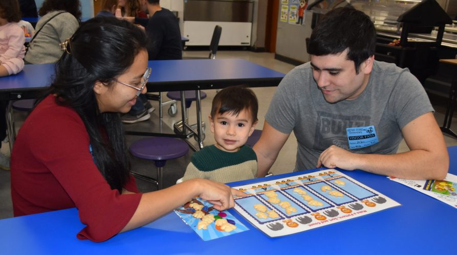 PR 25 Parent University 2025 Two adults help a young child with counting crackers