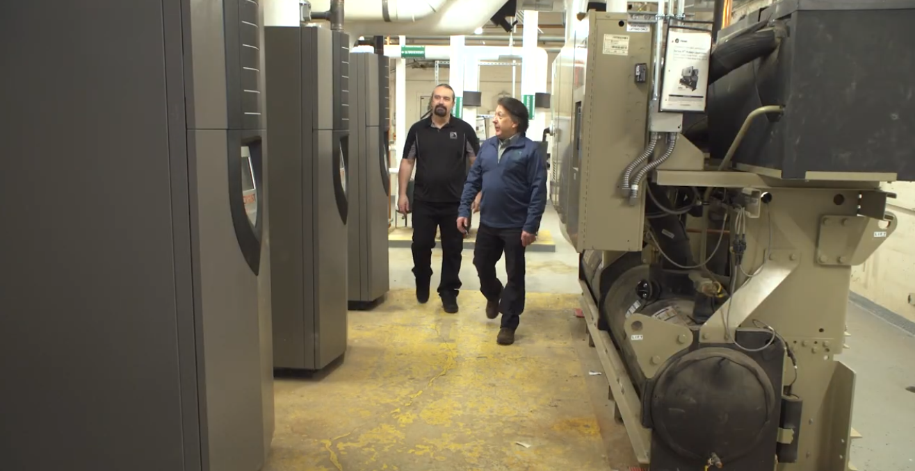 Two men walk by the new boilers at Oakman Elementary