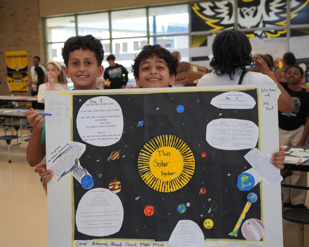 Students show off a display about the solar system.