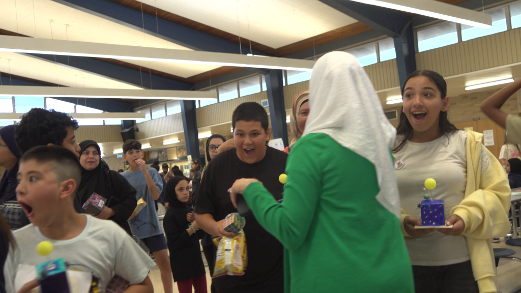 Students react after learning they won a prize during a special event at Stout Middle School.