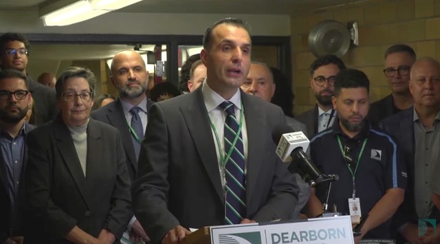 Superintendent Mike Esseily speaks as he is surrounded by other officials at a press conference in the basement of Lowrey School.
